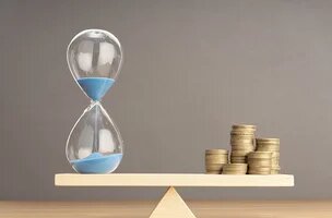 Balance avec sablier d'un côté et pièces de monnaie de l'autre côté